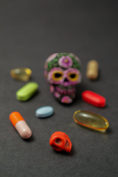 Calavera surrounded by pills on black background,  communicating the concept that drugs can be dangerous