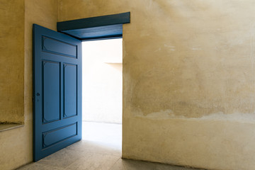 Blue wooden vintage door with yellow plaster wall
