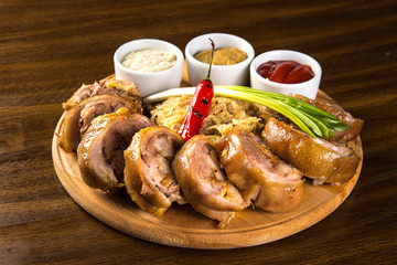 Roasted Pork Roulade with boiled cabbage and sauces on wooden tray