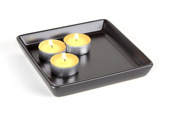 Three candles on black plate