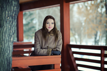 beautiful girl on the street in a wooden alcove in the winter. Portrait of a young woman