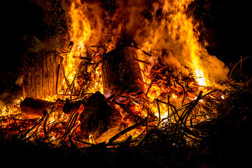 tongues of fire on branches and trunks burning in a big bonfire