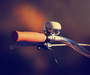 a close up of a bell ringer on the handle bars of a retro or vintage filter