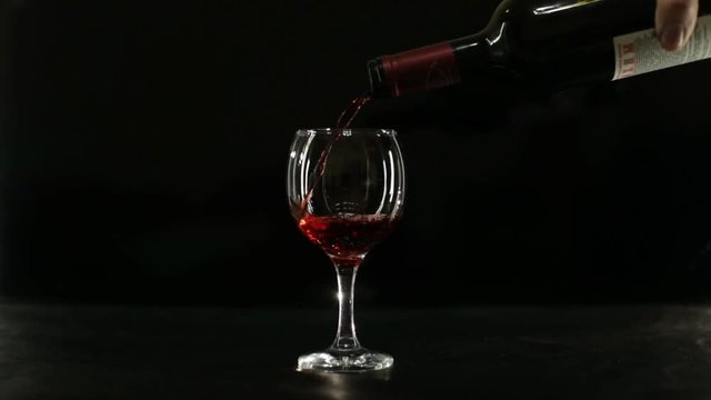 glass of red wine on a black background backlit