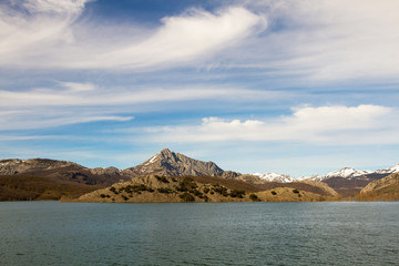 Fototapeta na wymiar Agua Embalsada en Pantano Rodeado de Montañas