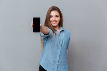 Naklejka premium Woman in shirt showing blank smartphone screen