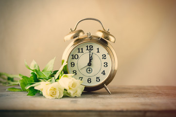 Naklejka premium View in retro alarm clock and bouquet of white roses