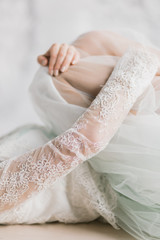 bride detail, lying with lace drace and hugging her legs