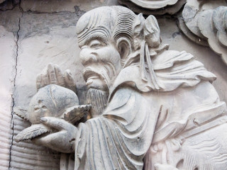 Stone carving of Chinese sage holding peach