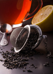 tea strainer with a cup on dark background