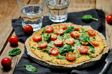 Cauliflower pizza crust with tomato and spinach