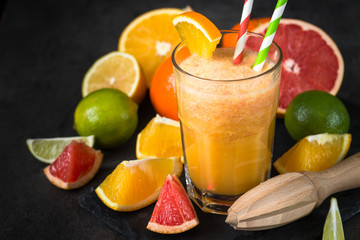 Fresh citrus smoothie juice at dark background.