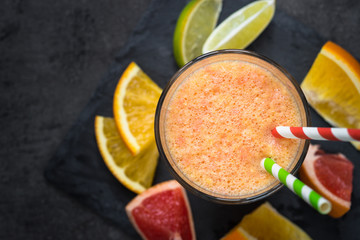 Fresh citrus smoothie juice at dark background. Top view