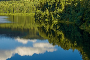 Mountain lake in clear weather, with the sky reflected in the water.