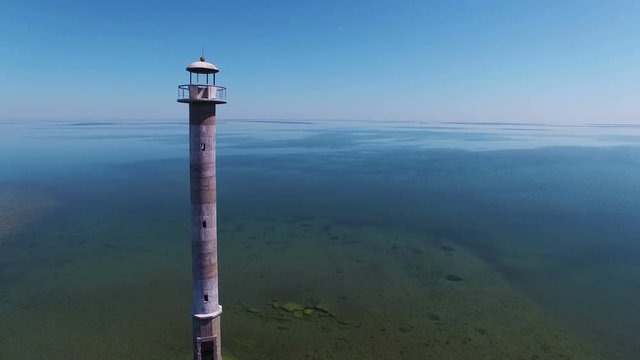4K. Flight over old lighthouse standing in the sea, aerial view. Estonia, Saaremaa island - Kiipsaare tuletorn.