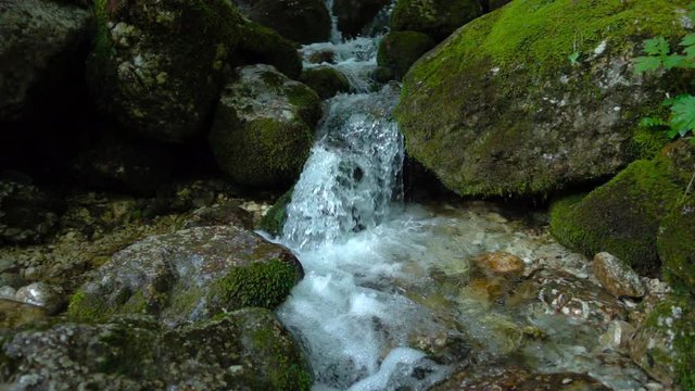 SLOW MOTION: flowing water over stones in mountines river