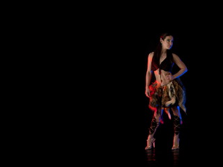 woman athlete in the Amazon costume with fur and skins posing on a black background in the scenic...