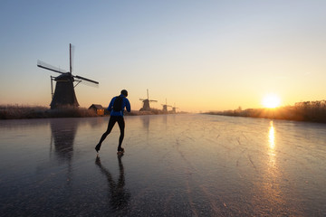 Ice skating at sunrise in the Netherlands - obrazy, fototapety, plakaty