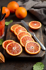 Fresh blood orange slices on wooden board, selective focus, vertical