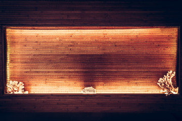 Wooden bamboo planks niche with warm orange light along the perimeter and copy space