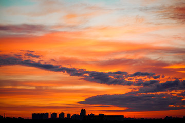 Sunrise in city landscape. Urban sunset. Rays of the sun above t