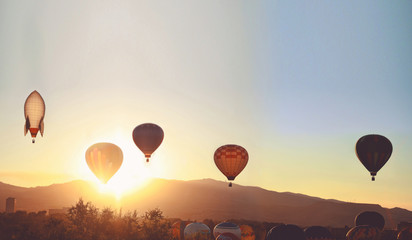 hot air balloons in the sky during sunrise toned with a retro vi