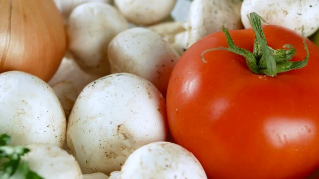 4K footage of various vegetables slow rotating with tomato, mushrooms, onions, cucumbers and other