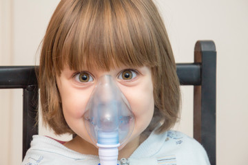 Beautiful girl using the inhalation mask