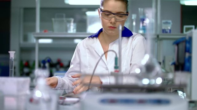 Young woman scientist preparing for laboratory working. Female scientist preparing. Young researcher in lab. Scientist in lab. Woman in lab coat. Scientist woman in science laboratory