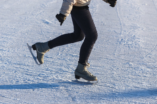 Image of Legs Young Girl in leather Figure Skates who are Skating at the Ice Rink