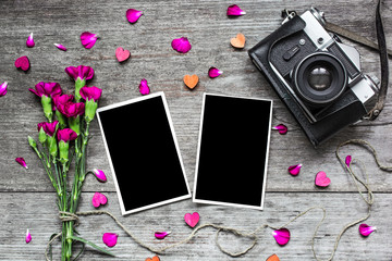 blank photo frames with vintage retro camera and carnation flowers