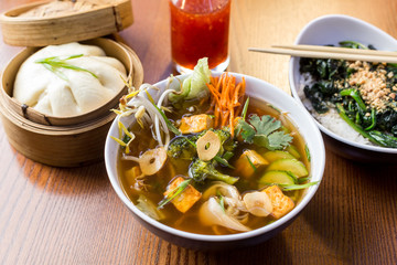 Asian dinner dishes - bao, soup and salad
