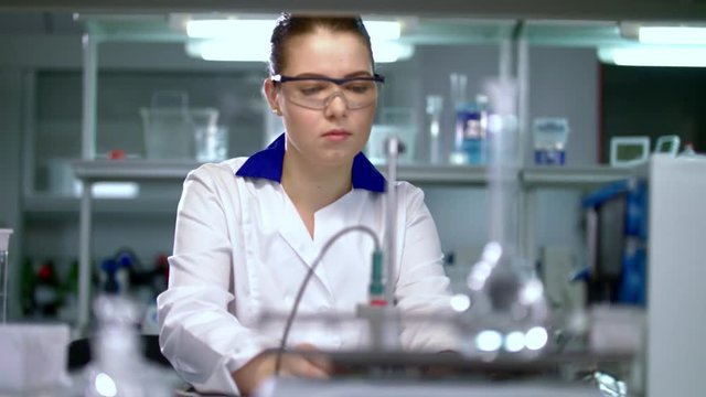 Female scientist preparing for experiment in pharmaceutical laboratory. Pharmacist preparing for pharmaceutical research in chemical lab. Assistant preparing for working in research laboratory.