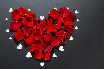 Beautiful red rose petals in shape of heart on black background. Postcard for Valentine's Day, March 8, mother's Day or wedding. Free space for text