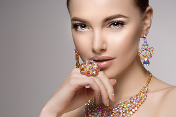 Beautiful woman in a necklace, earrings and ring. Model in jewel - obrazy, fototapety, plakaty