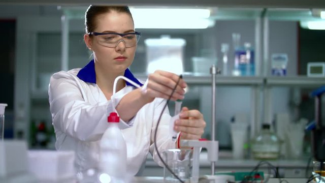 Young scientist in medical laboratory. Doctor preparing medical laboratory equipment for medical research. Female doctor lab. Clinician working with medical lab equipment