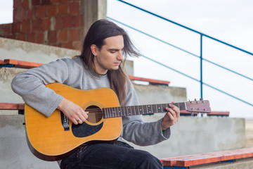 Guitar player playing song outdoor
