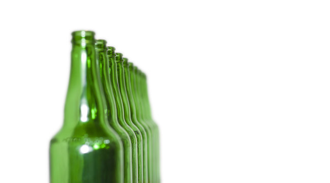 Row of open empty green bottles isolated on white background