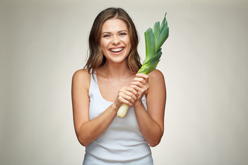 Happy smiling woman holding green leek.