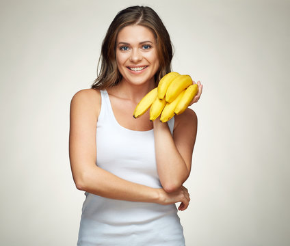 beautiful girl holding banana standing against isolated studio b