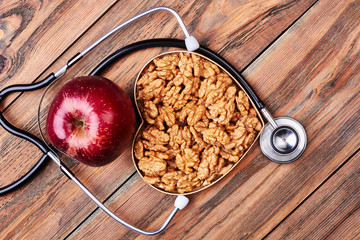 Apple, walnuts and stethoscope. Advertising of medical department.