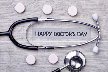 Stethoscope, tablets and card. International Doctor's Day Greeting.
