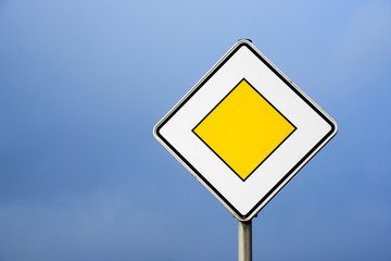 Priority road, european traffic sign against the clear blue sky