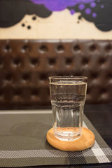 Glass of water with ice in restaurant dark room. selective focus