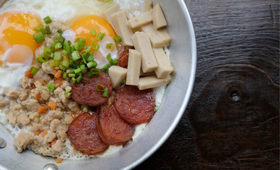Top view closeup sausage pork, pan fried eggs breakfast menu in a pan with wooden background, healthy concept.