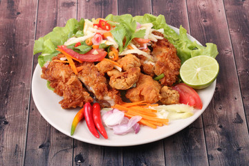 Spicy deep-fried chicken salad with roll green mango .