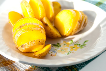 Baked potatoes in their skins yellow on a white plate