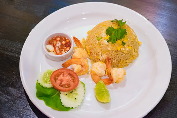 Shrimp Fried Rice in white dish on dark wood table.