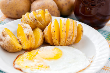 Baked potatoes and yellow eggs on a white plate