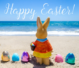 Easter bunny with color eggs on the ocean beach
